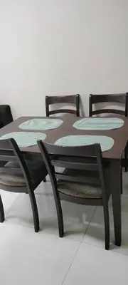 a wooden table with two chairs around it at 1 Bedroom Near Airport by Rqui in Manila