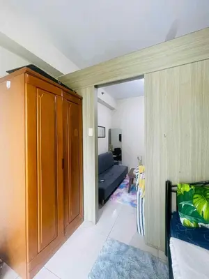 a living room with a couch and a sliding door at Breeze Residences in Manila