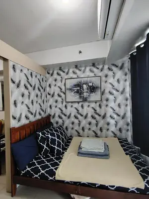 a small bed in a room with a wall at SM MOA staycation condotel in Manila