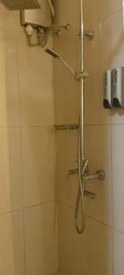 a shower with a shower head in a bathroom at Shell Residence in Manila