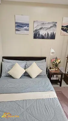 a bedroom with a bed with two pillows on it at Cozy Staycation in Mandaluyong in Manila