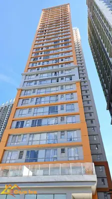 a tall building with a blue sky in the background at Cozy Staycation in Mandaluyong in Manila