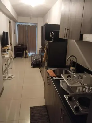 a kitchen with a sink and a counter top at Sojourn in S Residences in Manila