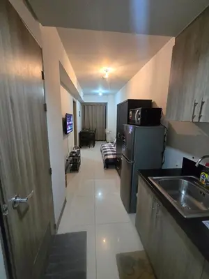 a small kitchen with a sink and a refrigerator at Sojourn in S Residences in Manila