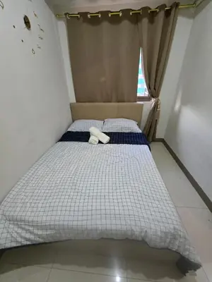 a small bed in a room with a window at Sojourn in S Residences in Manila