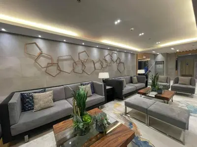 a living room with couches and tables and a wall at Sojourn in S Residences in Manila