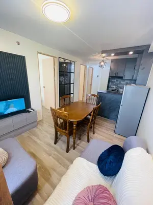 a living room with a table and a dining room at E&L Family Suite in Manila