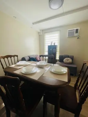 a dining room table with plates and chairs in a room at E&L Family Suite in Manila