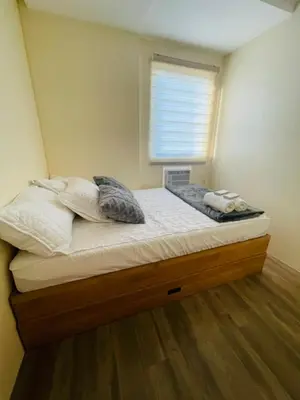 a small bed in a room with a window at E&L Family Suite in Manila