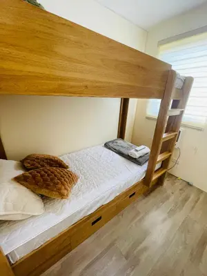 a bedroom with a bunk bed with white sheets at E&L Family Suite in Manila
