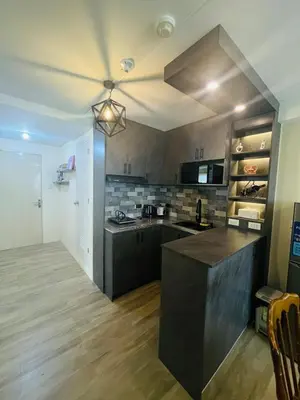 a large kitchen with a counter top and a ceiling at E&L Family Suite in Manila