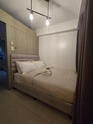 a bedroom with a bed with a cat on it at Gracie's Suites by Staycation With FREE Parking in Manila