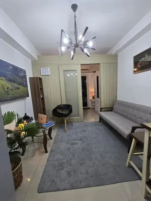 a living room with a couch and a chandelier at Gracie's Suites by Staycation With FREE Parking in Manila