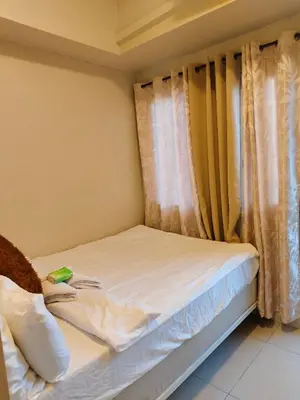 a small bedroom with a bed with curtains at Jazz Residence in Manila