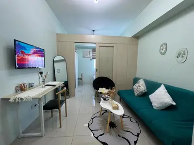 a living room with a green couch and a desk at cozy green in Manila