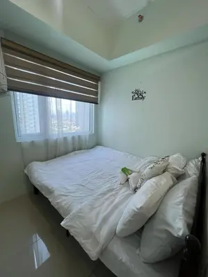 a white bed in a room with a window at cozy green in Manila