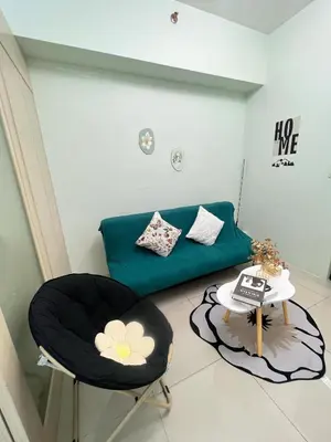 a living room with a couch and a table at cozy green in Manila