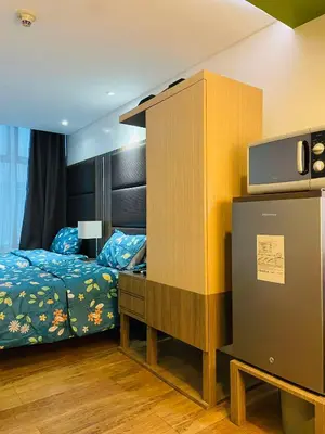 a bedroom with a bed and a cabinet with a tv at Folks Hub in Manila