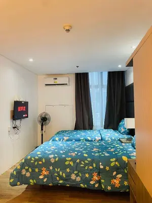 a bedroom with a bed with a blue comforter at Folks Hub in Manila