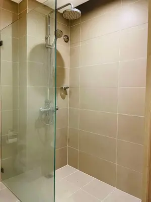 a shower with a glass door in a bathroom at Folks Hub in Manila