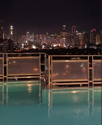 a view of a city at night from a swimming pool at Folks Hub in Manila