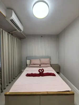a bedroom with a bed with a red ribbon on it at Shell Residence Moa in Manila