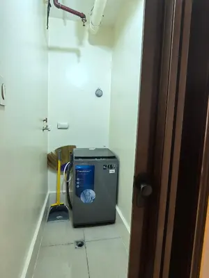 a room with a washing machine sitting on the floor at Shell Residence Moa in Manila