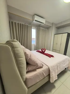 a room with a bed with a red ribbon on it at Shell Residence Moa in Manila