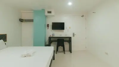 a room with a bed and a desk with a computer at Sans Hotel near Enchanted Kingdom Santa Rosa Laguna in Santa Rosa