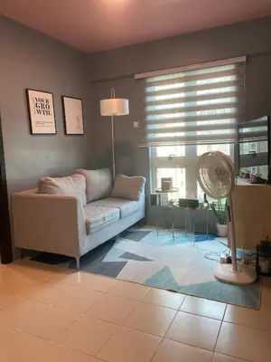 a living room with a couch and a fan at JACC Condotel in Manila