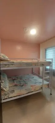 two bunk beds in a room with a window at JACC Condotel in Manila