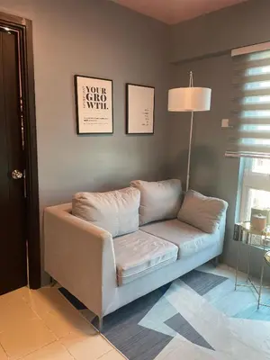a living room with a couch and a lamp at JACC Condotel in Manila