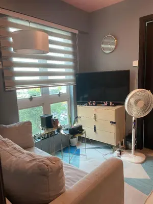 a living room with a couch and a flat screen tv at JACC Condotel in Manila