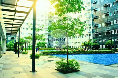 a building with a swimming pool in front of a building at iWandr Suites at SMDC Charm Residences in Manila