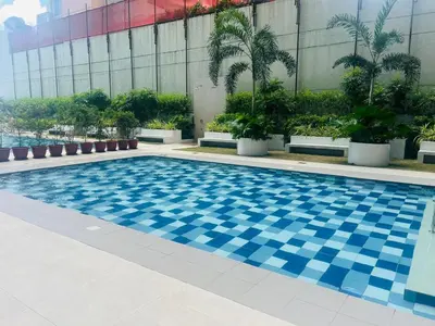 a swimming pool in a building with palm trees at The Makati Suites at Red Residences, Premium Studio, City View, Makati CBD, Wi-fi in Manila