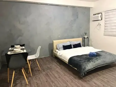 a bedroom with a bed and a table and a chair at Amaia step parkway nuvali studio in Calamba