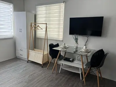 a living room with a table and chairs and a television at Amaia step parkway nuvali studio in Calamba