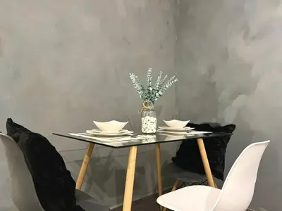 a table with chairs and a vase with flowers on it at Amaia step parkway nuvali studio in Calamba