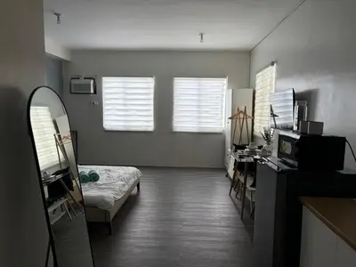 a room with a bed and a desk in it at Amaia step parkway nuvali studio in Calamba