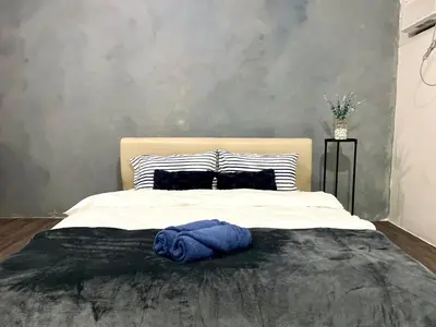 a bed with a blue blanket on top of it at Amaia step parkway nuvali studio in Calamba