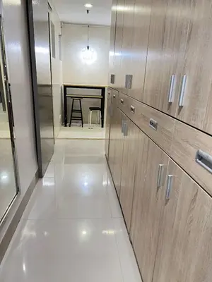 a kitchen with wooden cabinets and a table in the background at R&R Empire Rental Unit in Manila