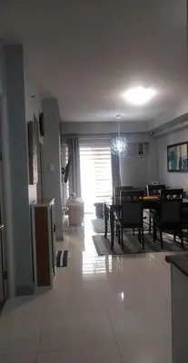 a living room with a table and a dining room at Sweetay sweet condo in Manila