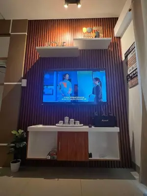 a tv on a wall in a room at Win-Ter Staycation 1 in Manila