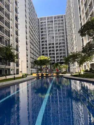 a large swimming pool in front of tall buildings at Win-Ter Staycation 1 in Manila