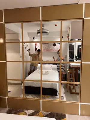 two people standing in a room with a bed at Win-Ter Staycation 1 in Manila
