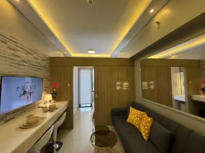 a living room with a couch and a tv at Home of Mari in Shore 2 Residences Room 10107 near Airport, SM MOA, US Embassy Manila by Prime Stay MOA in Manila