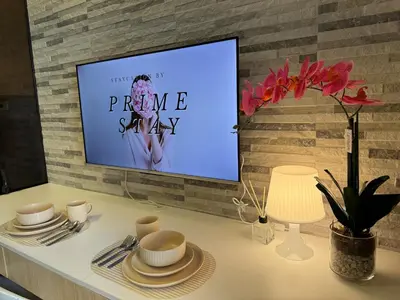 a tv screen on a brick wall with a table with plates and cups at Home of Mari in Shore 2 Residences Room 10107 near Airport, SM MOA, US Embassy Manila by Prime Stay MOA in Manila