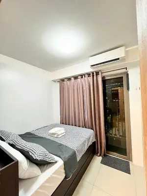 a bedroom with a bed and a window at Shore 1 Tower D in Manila