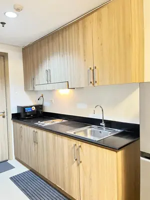 a kitchen with wooden cabinets and a sink at Shore 1 Tower D in Manila