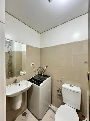 a bathroom with a white toilet and a sink at Shore 1 Tower D in Manila